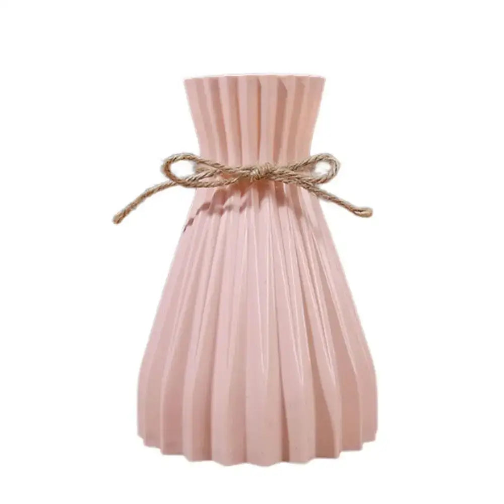 A blush pink pleated plastic flower vase with origami style design and rustic twine bow by decorbites