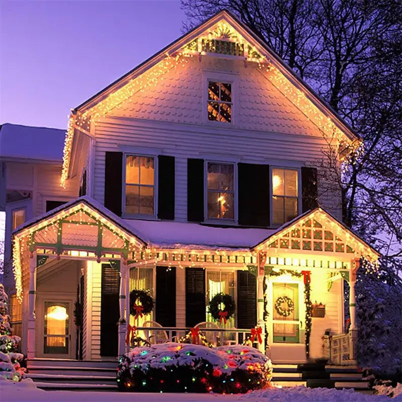 A white two-story house with black shutters decorated with decorbites™ outdoor christmas waterfall curtain string lights and wreaths