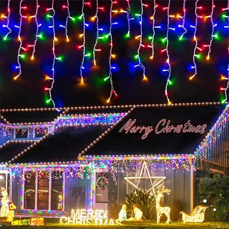 Colorful led curtain string icicle lights cascade above a decorated house featuring outdoor Christmas waterfall lights