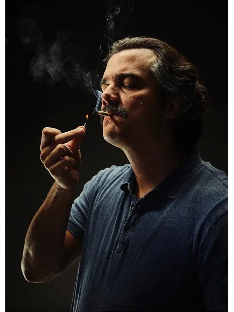 A man with dark hair and mustache in a blue denim polo shirt featured in DecorBites™ lord Pablo Escobar wall art canvas