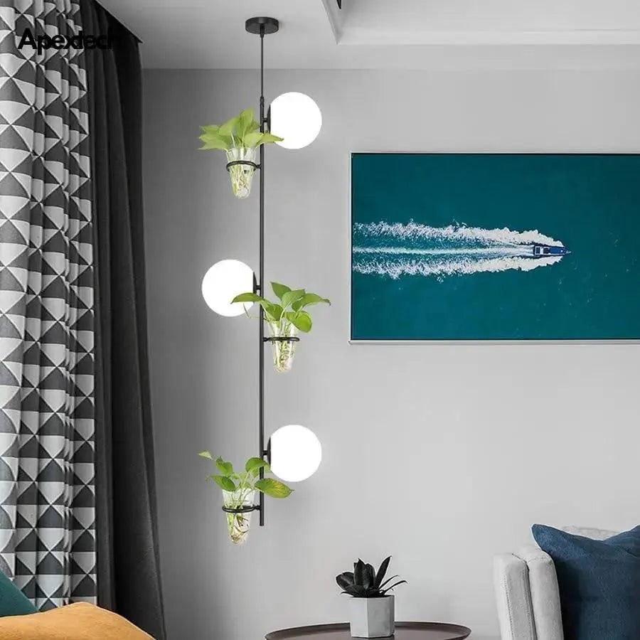 DecorBites pendant planter light featuring black metal frame, three white spherical bulbs, and glass planters with green foliage