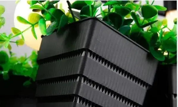 Black plastic DecorBites™ planter light chandelier with textured ribbed exterior and green foliage spilling over the top