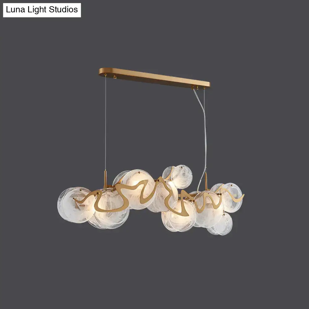 Gold-toned DecorBites postmodern circle pendant light with clear glass orbs and sculptural metal arms LED light fixture