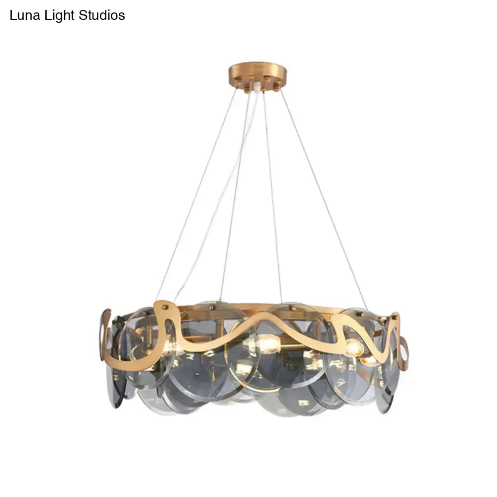 Gold-toned decorbites postmodern circle pendant light featuring translucent gray glass discs and ornate metal accents
