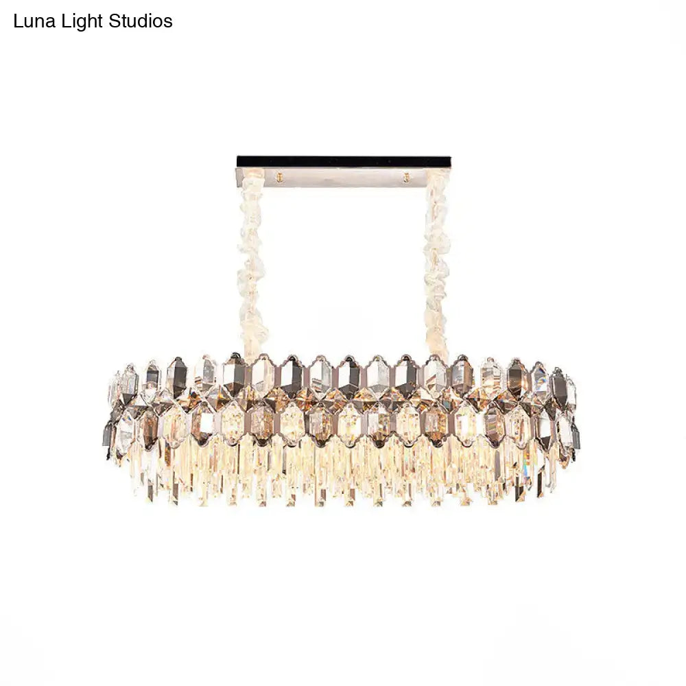 A modern DecorBites island light fixture with rectangular chrome frame and twisted crystal chains for dining room use
