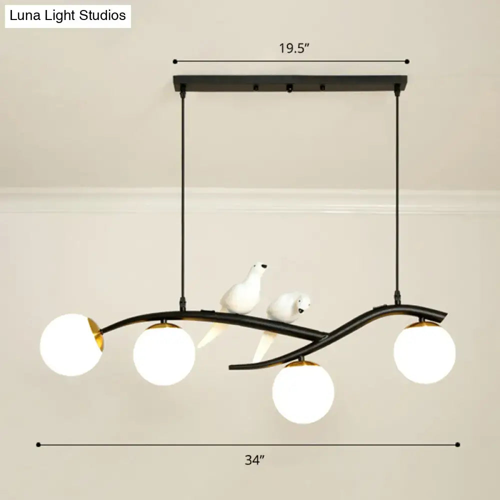 Black metal decorbites island lamp tree with three white glass globes and ceramic bird figurines on lamp tree branch design