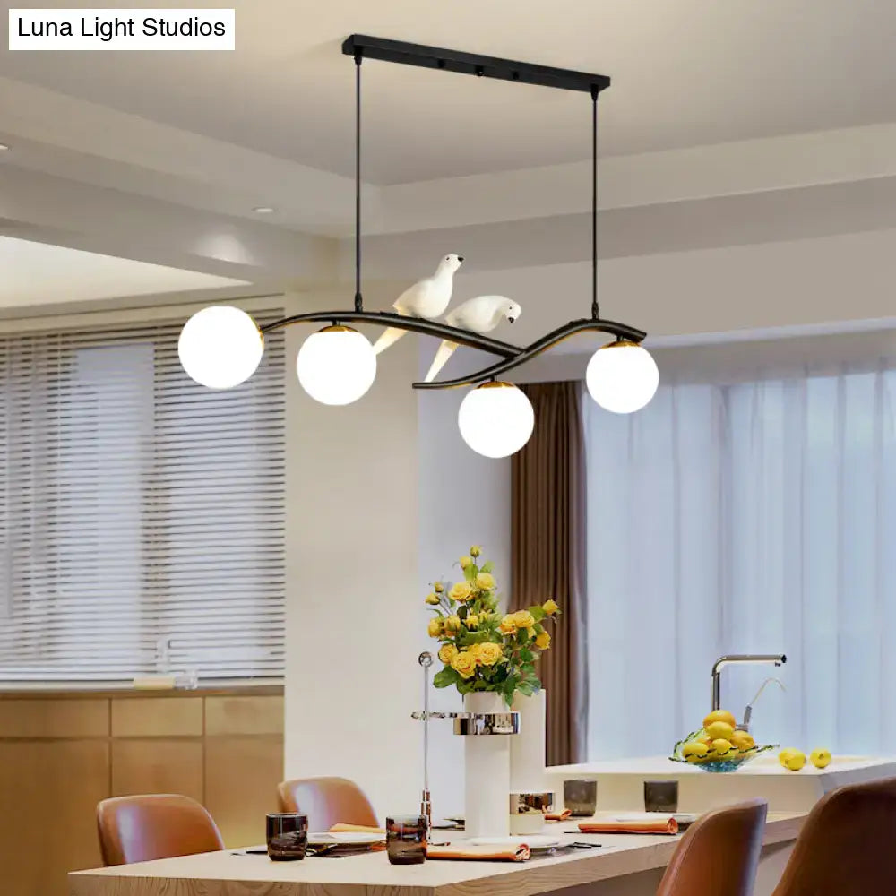 Modern black metal island lamp tree with three white glass bulbs and sculpted white doves on lamp tree branch