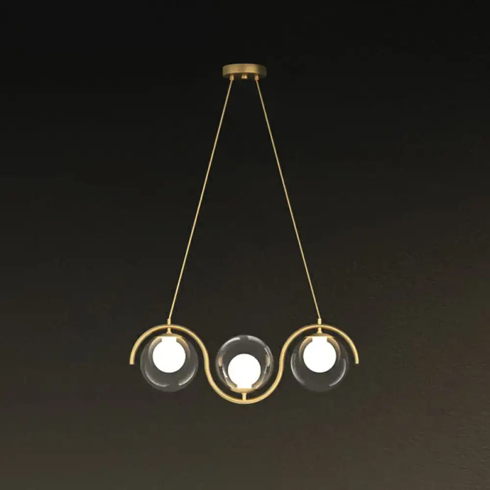 DecorBites modern brass hanging lamp with three clear glass shade spheres and curved metallic arms