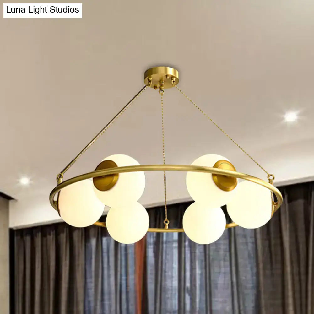Decorbites postmodern metal chandelier with brass finish circular frame and five frosted glass globe shades