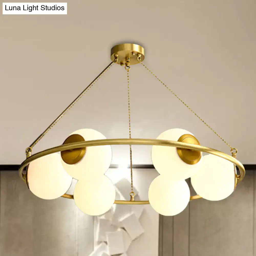 DecorBites™ postmodern circular chandelier light with brass finish and five frosted glass globe shades