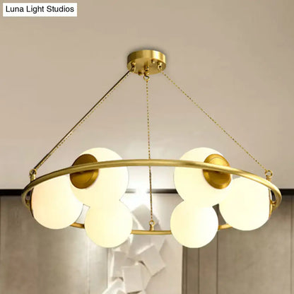 DecorBites™ postmodern circular chandelier light with brass finish and five frosted glass globe shades