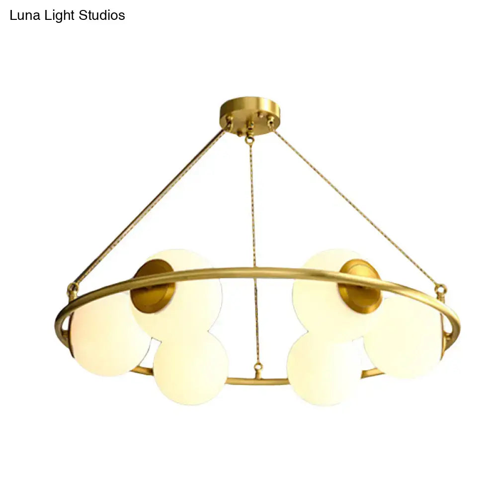 Gold-toned circular chandelier light with frosted glass shades in brass finish by decorbites postmodern design