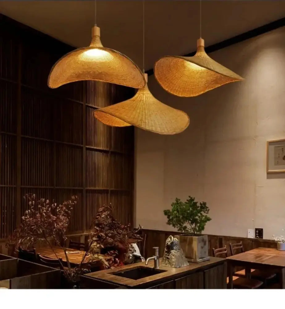Three golden woven bamboo DecorBites™ rattan hanging pendant lights with dimmable shades hang from the ceiling