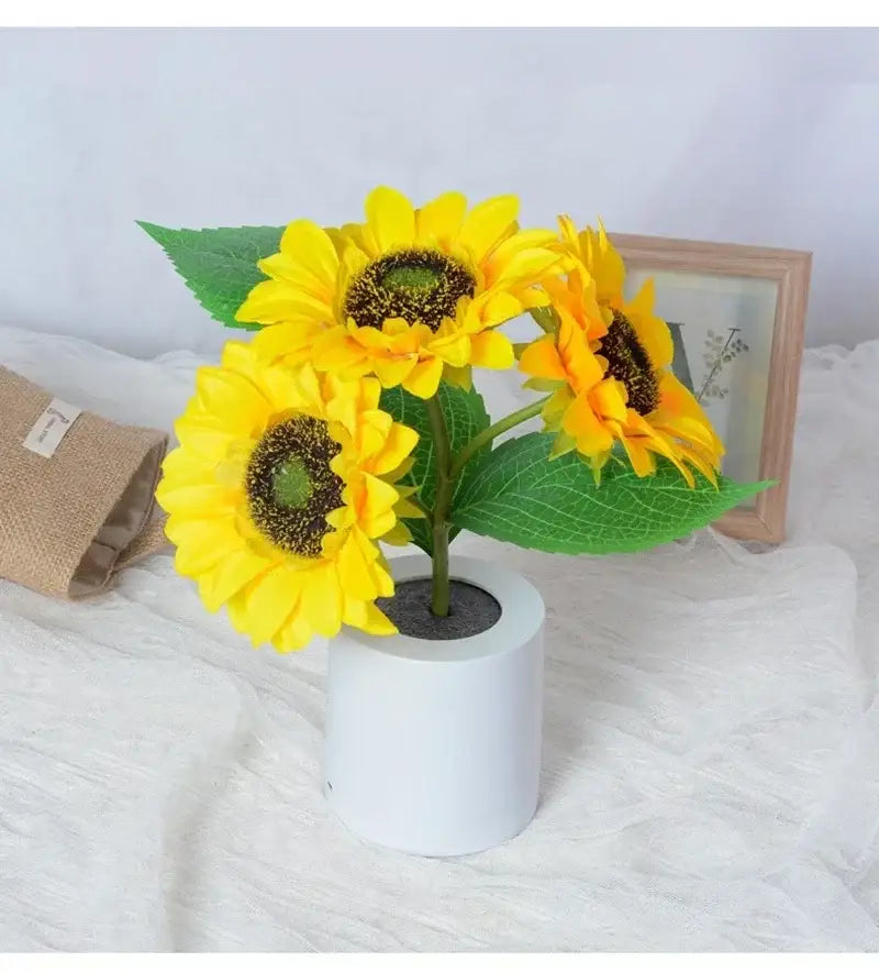 Bright yellow artificial sunflowers with green leaves in a white pot featuring a rechargeable led night light for bedroom