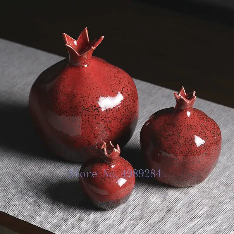 Set of three glossy red pomegranate ceramic vases with speckled glaze and crown tops for modern home decor