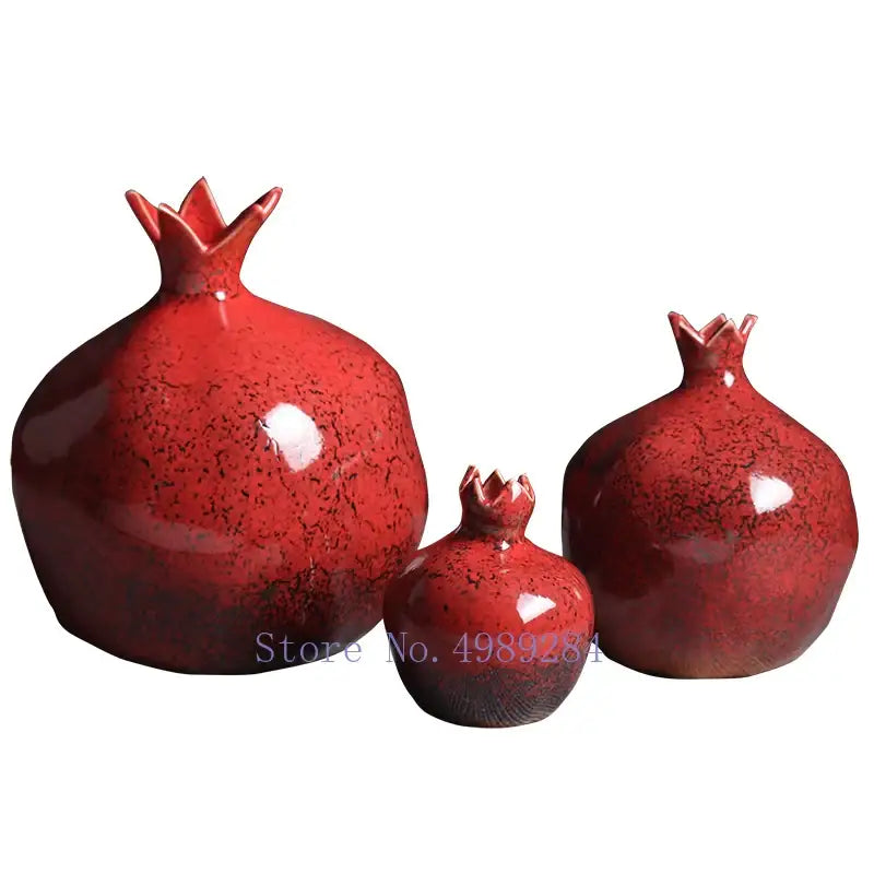 Set of three glossy red pomegranate ceramic vases with speckled texture and crown tops for modern home decor
