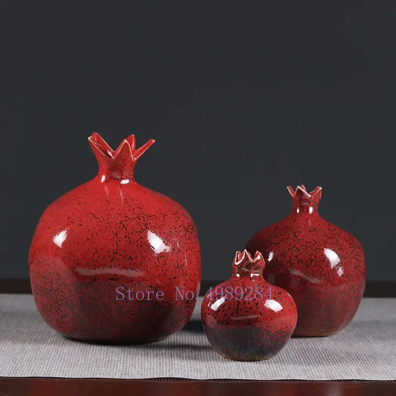 Three glossy red pomegranate ceramic vases with speckled glaze and crown tops for a modern home by DecorBites