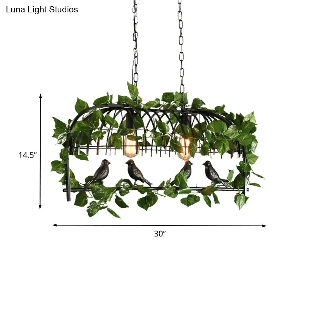 Black wrought iron retro birdcage island light fixture with four dark birds and green artificial vines hanging