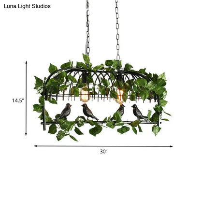 Black wrought iron retro birdcage island light fixture with four dark birds and green artificial vines hanging
