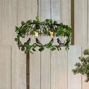 Black wrought iron retro birdcage island light fixture with four bulbs, artificial ivy, and detailed black birds
