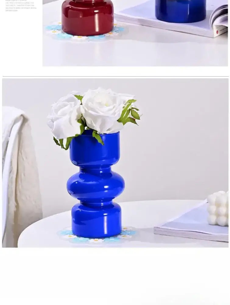 Vibrant cobalt blue ceramic vase with stacked segments holding white roses in decorbites retro glass vase style