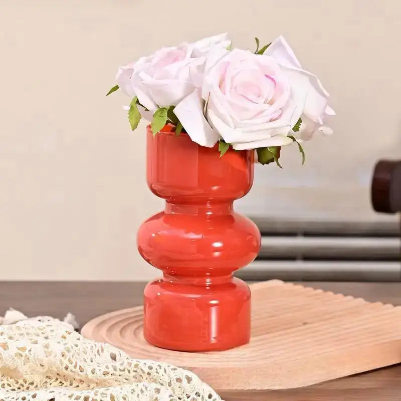 Vibrant red ceramic retro glass vase with stacked segments holding delicate white roses for flower arrangements