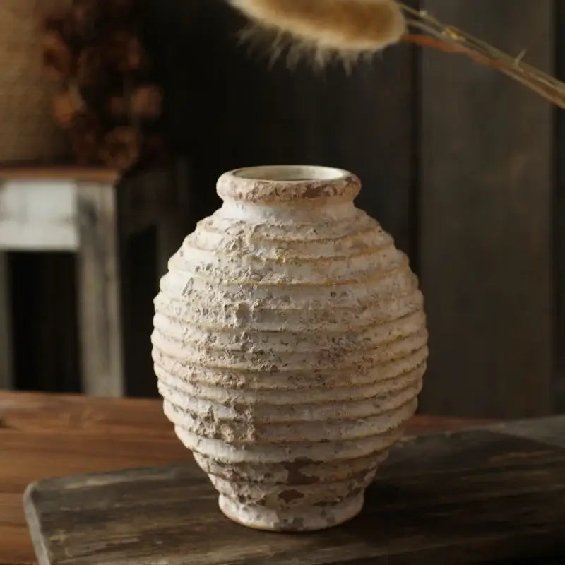 DecorBites™ retro handmade off-white clay vase with horizontal ridges and weathered texture on wooden surface
