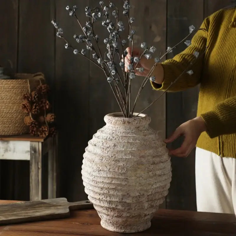 DecorBites™ retro handmade off-white ceramic vase with textured ribbed surface holding silver-toned branches