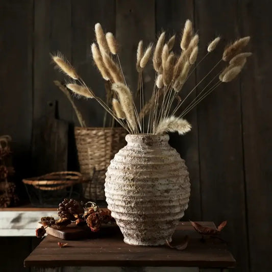 DecorBites™ retro handmade white ceramic vase with horizontal ridges holding dried beige bunny tail grass bouquet