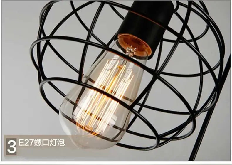 A glowing edison-style bulb pendant light with visible filament encased in a black retro iron art wire cage
