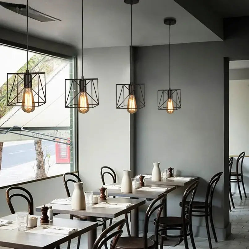 Decorbites™ retro iron art pendant light with black metal geometric frame and exposed filament bulbs above tables