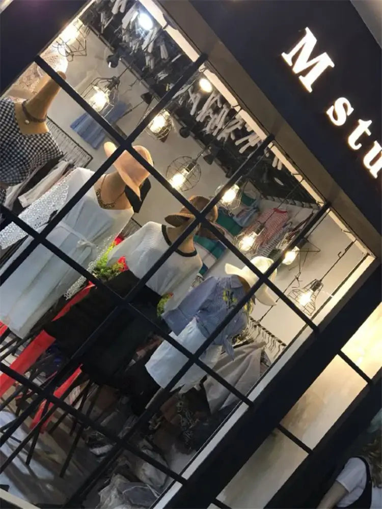 The DecorBites™ retro iron art pendant light features vintage industrial style iron art above a summer-themed storefront display