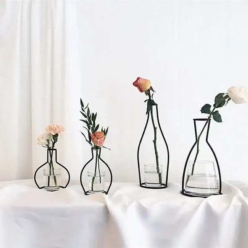 Minimalist black metal retro iron flower vase with clear glass base holding a single rose or greenery for decor