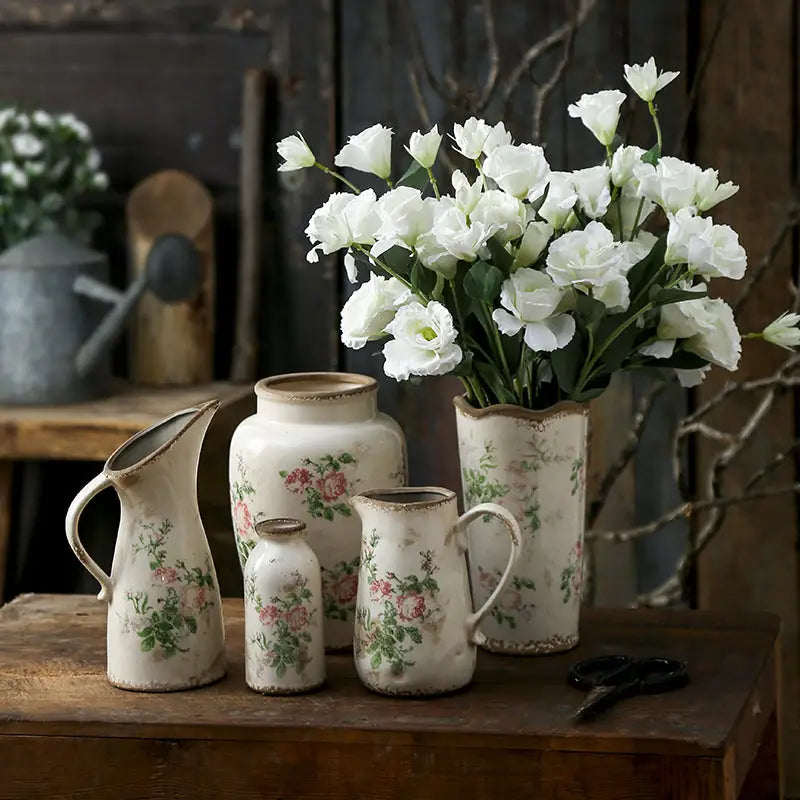 A collection of cream-colored retro nordic ceramic vases with delicate pink rose floral patterns ideal for home decor
