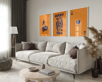 Light gray upholstered sofa with soft rounded armrests placed beside decorbites retro queen of hearts canvas wall art set