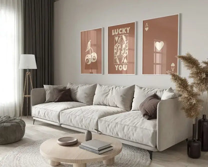 Light gray upholstered sectional sofa with dark brown throw pillows and metal legs below DecorBites retro hearts canvas wall art set