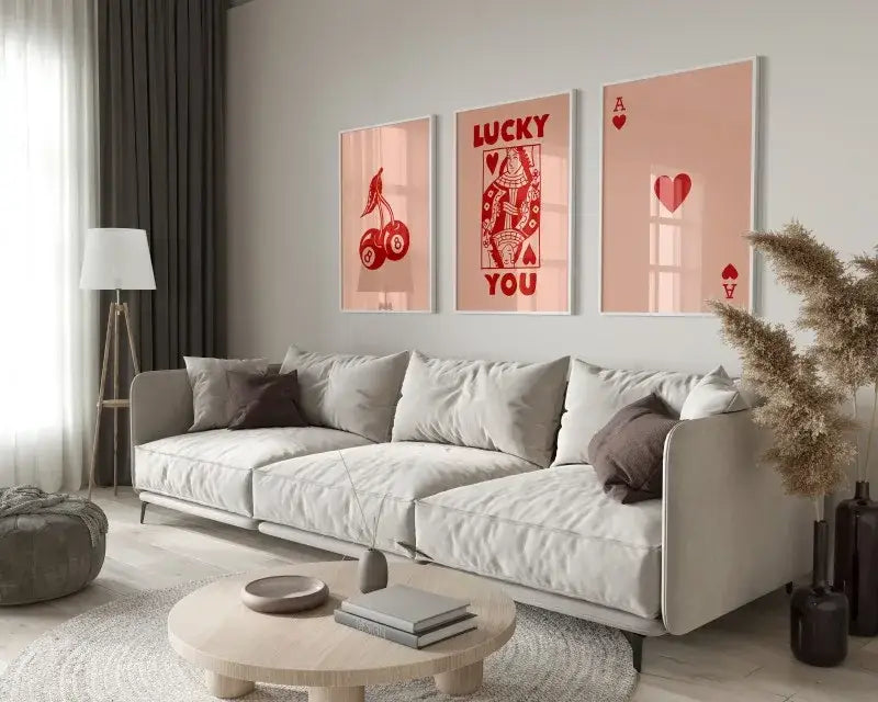 Light gray upholstered sofa with dark brown throw pillows beneath DecorBites™ retro queen of hearts canvas wall art set