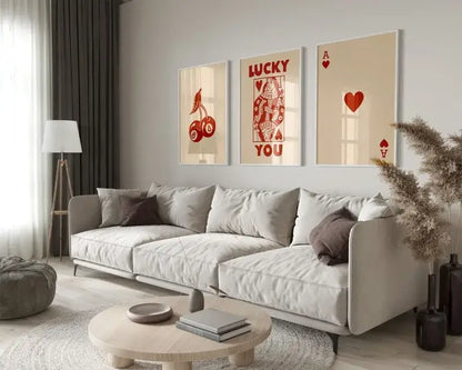 Light gray upholstered sectional sofa with dark brown throw pillows beside decorbites retro queen of hearts wall art set
