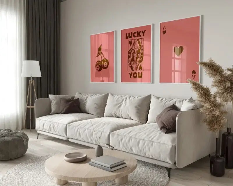 A modern beige sectional sofa with plush cushions and dark gray throw pillows beside decorbites retro queen of hearts wall art set