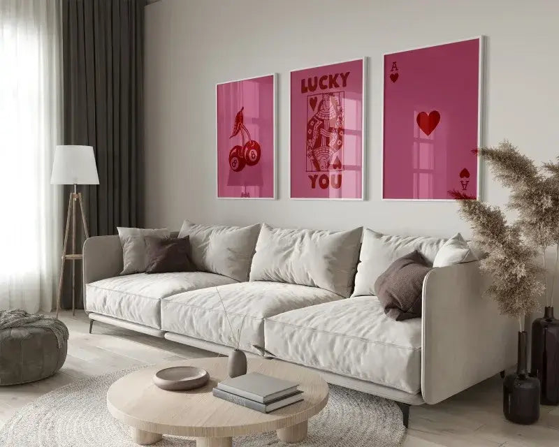 Three framed pink hearts canvas wall art set featuring retro queen of hearts designs above beige sofa