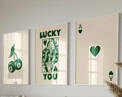 Set of three framed decorbites retro queen of hearts wall art prints with green playing card and lucky charm designs on cream background