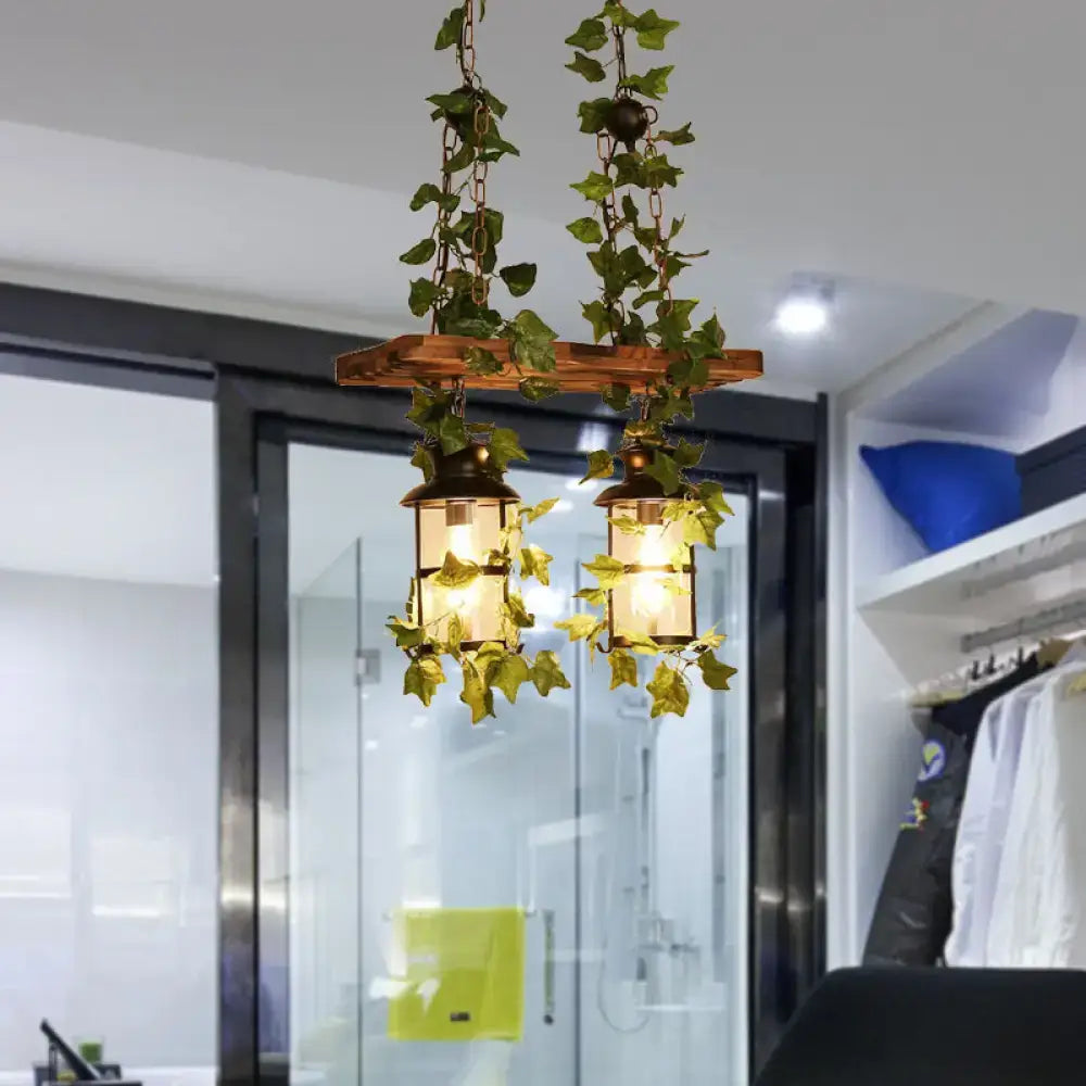 Rustic wooden beam island ceiling light with two brass lanterns and pink green plant flower decor vines