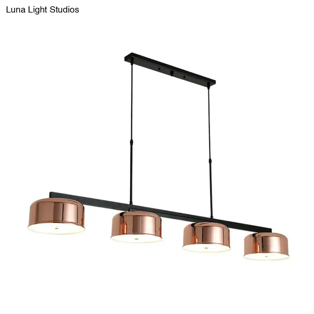 DecorBites rose gold metal pendant light fixture with four cylindrical shades and black horizontal bar for dining room