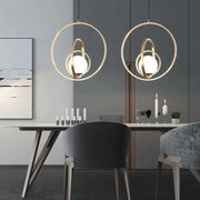 Gold-toned DecorBites™ rotating gold ring pendant light with circular intersecting rings and frosted glass globes