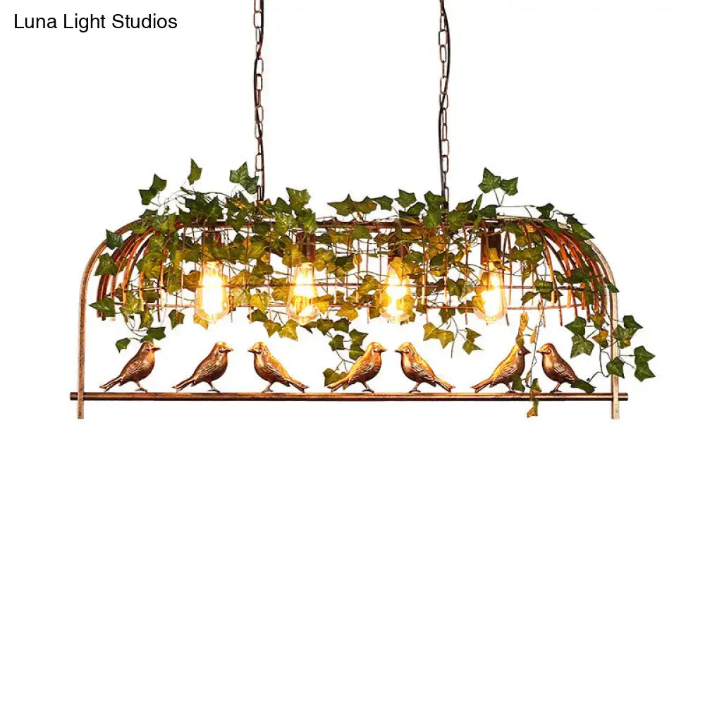 Bronze-colored wrought iron birdcage island light fixture with five ornamental birds and ivy vines featuring glowing bulbs and wide fixture width