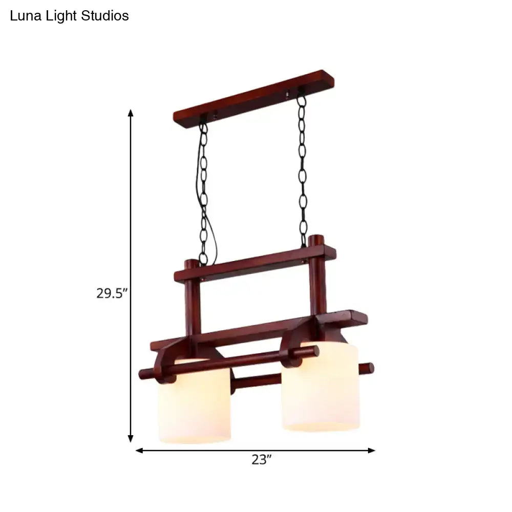 Dark wood frame island light with two white glass frosted shades suspended by black chains for dining room use