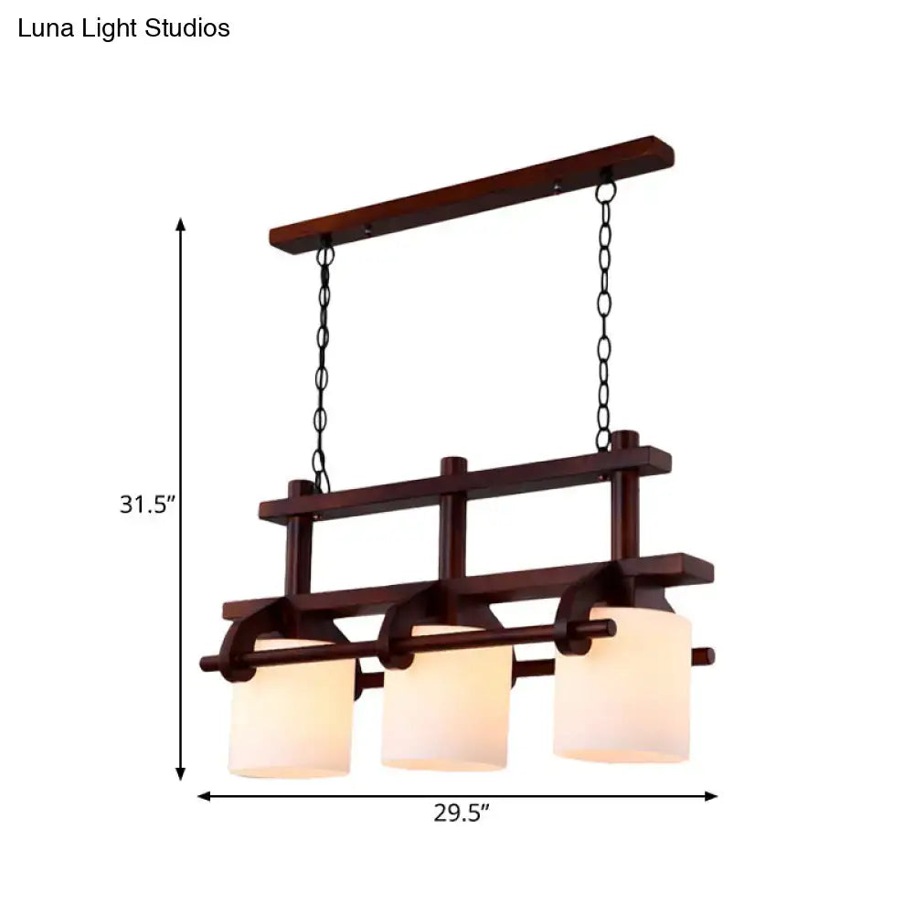 Dark wood-framed island light with three white glass shades suspended by black chains for dining room decor