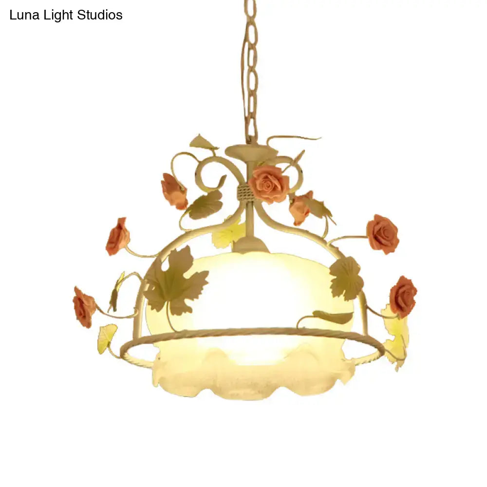 Delicate gold-toned scallop chandelier light fixture with ornate rose motifs and frosted opal glass shade for living room
