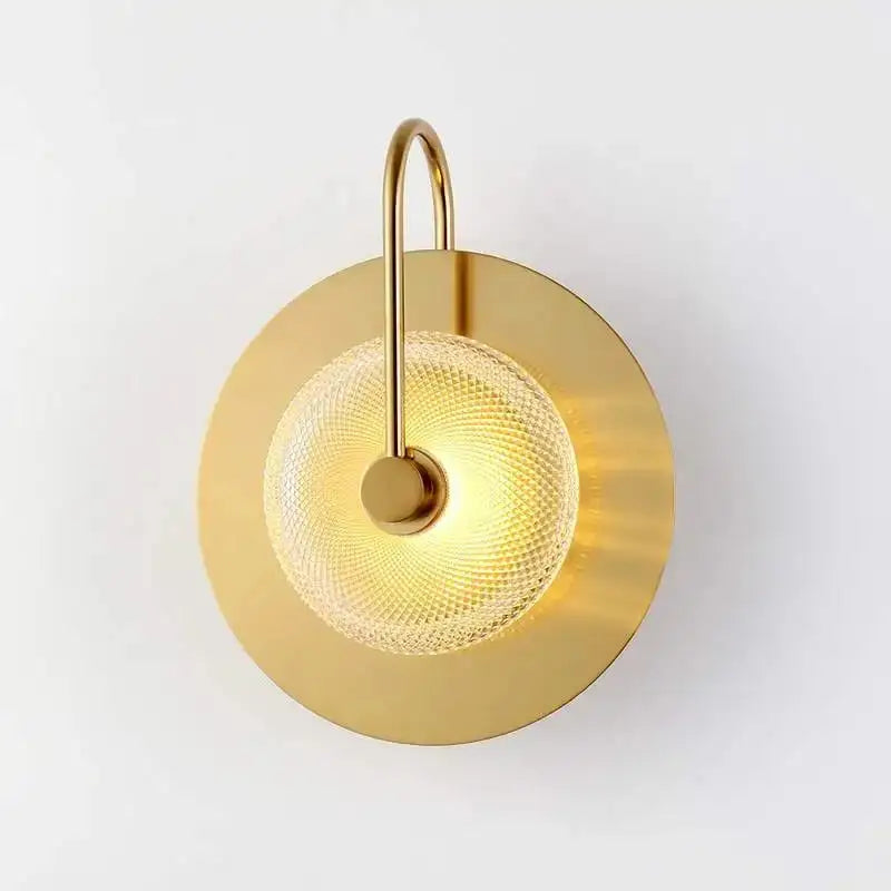 Decorbites™ scandinavian brass wall sconce with premium brass wall base, curved arm, and textured glass diffuser emitting warm light