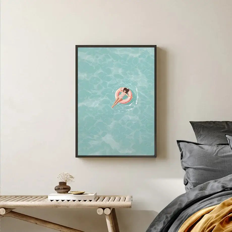 DecorBites™ serene beach watercolor illustration print of a woman floating on pink ring in turquoise water framed black